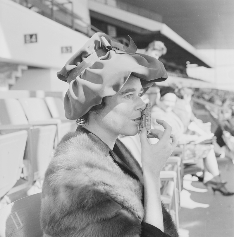 Woman kissing a ticket at the Woodbine Racetrack, 1960. Image no. ASC03814.
